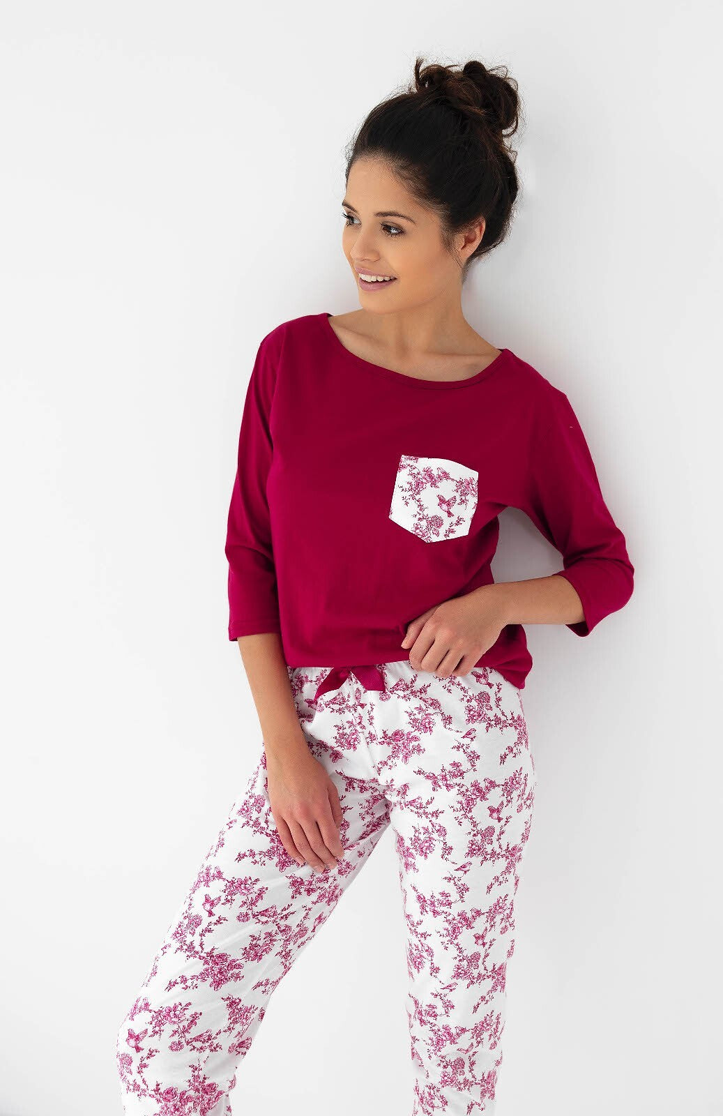 Riscopri il comfort con questo pigiama donna in cotone di alta qualità, completo di maglia con maniche 3/4 e pantaloni lunghi con elegante stampa floreale. Perfetto per chi desidera un look raffinato anche a casa, con dettagli come la taschina sul petto e la coccarda in raso in vita.&nbsp;