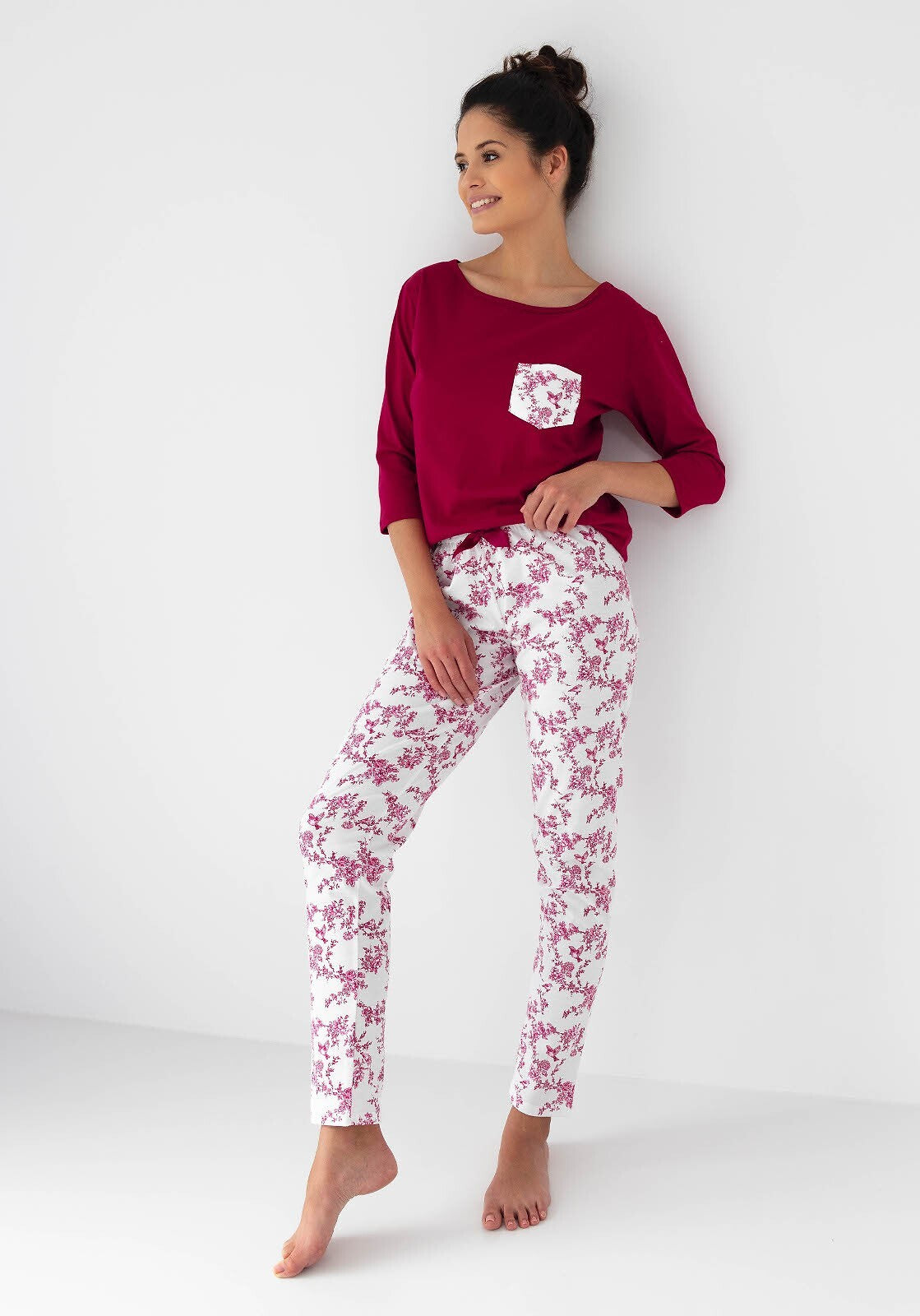 Riscopri il comfort con questo pigiama donna in cotone di alta qualità, completo di maglia con maniche 3/4 e pantaloni lunghi con elegante stampa floreale. Perfetto per chi desidera un look raffinato anche a casa, con dettagli come la taschina sul petto e la coccarda in raso in vita.&nbsp;