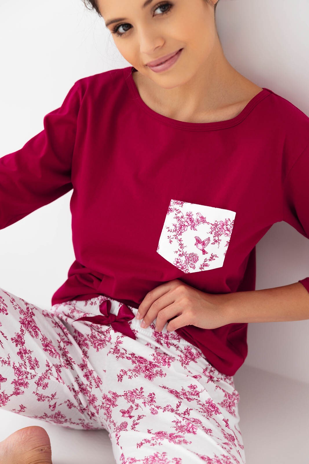 Riscopri il comfort con questo pigiama donna in cotone di alta qualità, completo di maglia con maniche 3/4 e pantaloni lunghi con elegante stampa floreale. Perfetto per chi desidera un look raffinato anche a casa, con dettagli come la taschina sul petto e la coccarda in raso in vita.&nbsp;