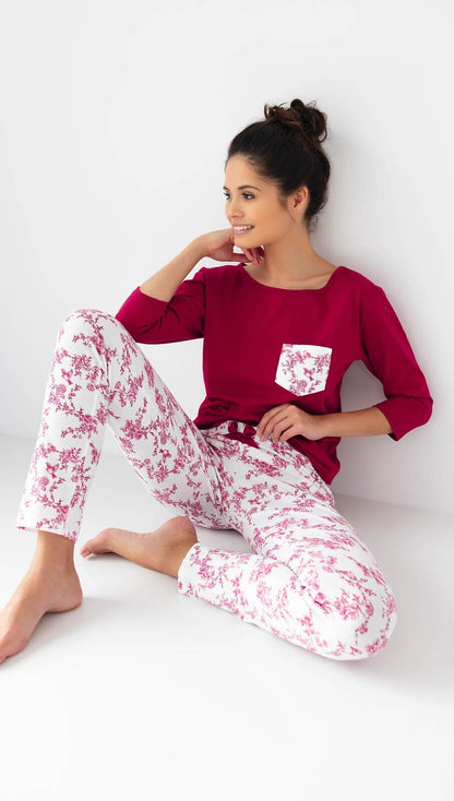 Riscopri il comfort con questo pigiama donna in cotone di alta qualità, completo di maglia con maniche 3/4 e pantaloni lunghi con elegante stampa floreale. Perfetto per chi desidera un look raffinato anche a casa, con dettagli come la taschina sul petto e la coccarda in raso in vita.&nbsp;